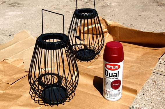 Two black wire candle holders with a paint and primer spray can.