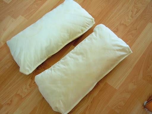 White color bed pillows are in the wooden floor.