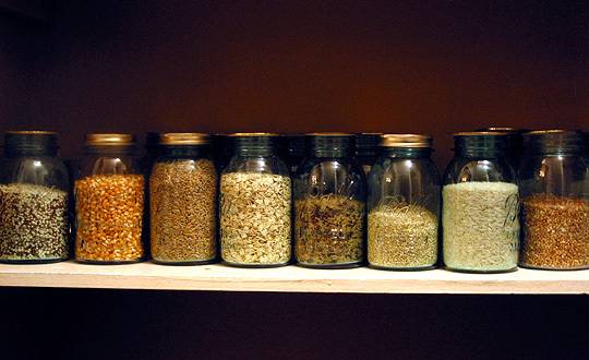 "Canning jars are  placed in a shelf that are perfect for storing a variety of pastas and grains"