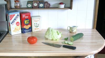 Knife and vegetables are in the wooden table.