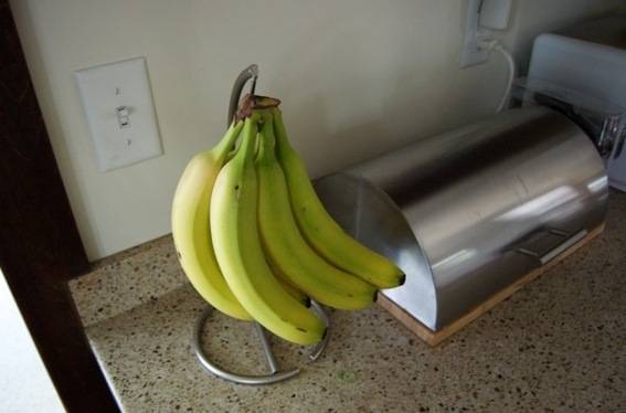 Stainless steel banana hanger on kitchen platform.