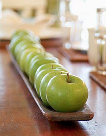 Green apples are arranged in a row on the table.