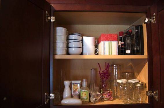 Two shelves with mason jars, coffee cups and other assorted trinkets.