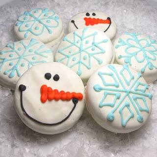 Several cookies are decorated with blue icing and snow man faces.