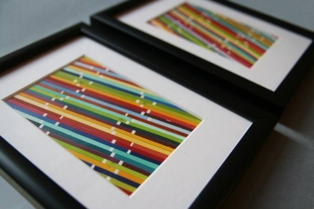 Two black picture frames with white mats and colored stripes as the picture.