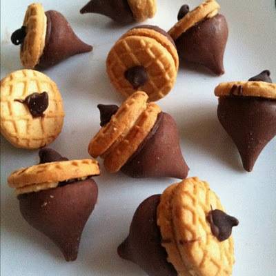 Several chocolate cookie acorns are on a table.