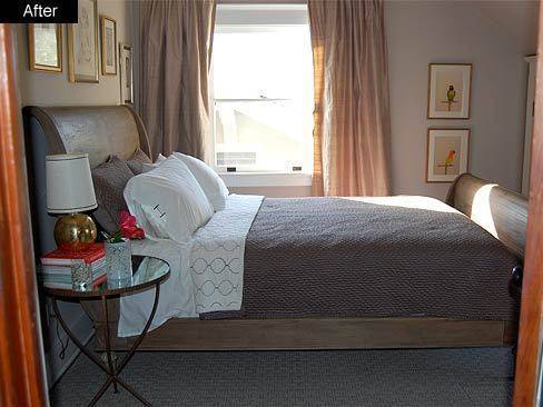 A neatly made bed in a small bedroom with a lamp and open window.