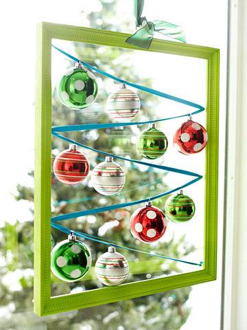 Christmas balls decorating a window with a green frame.