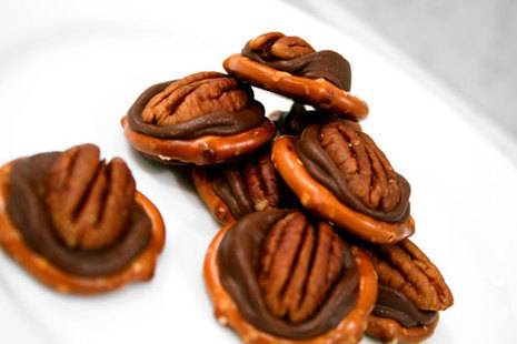 Chocolate pretzels with pecans are bunched together.