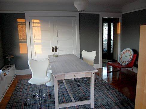 A table and white chairs is in the living room.