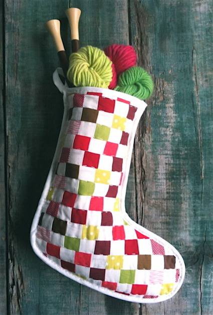 A checkered stocking with spools of thread in it.