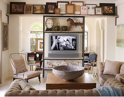A living room with framed pics over a television.