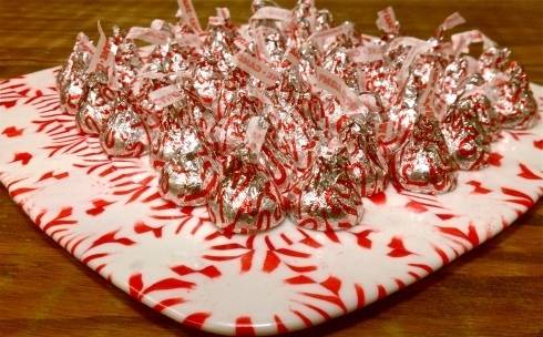 A candy bowl made of candy holds chocolate kisses.