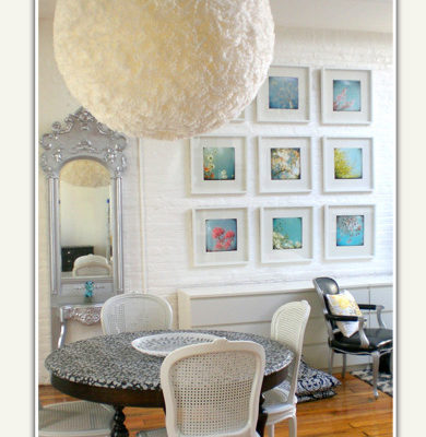 A dining room with a giant white ball for a light.