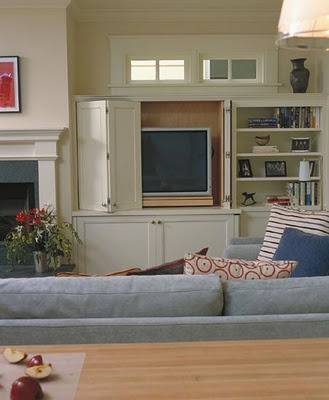 An image of a living room showing the back of a couch and a tv in an entertainment center.