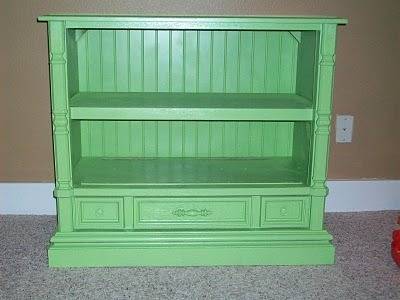 A green piece of furniture in a room with a brown room.