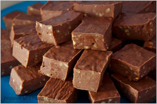 A pile of cut brownies with nuts on a blue plate.