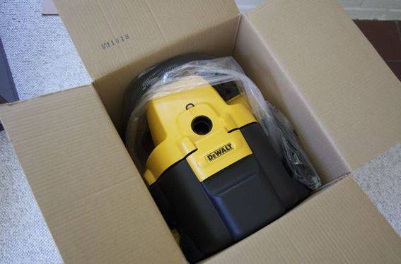 A yellow and black tool still in the cardboard box.