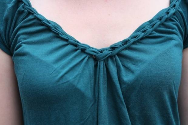 Green v-neck blouse with a ruffled edge and short gathered sleeves.