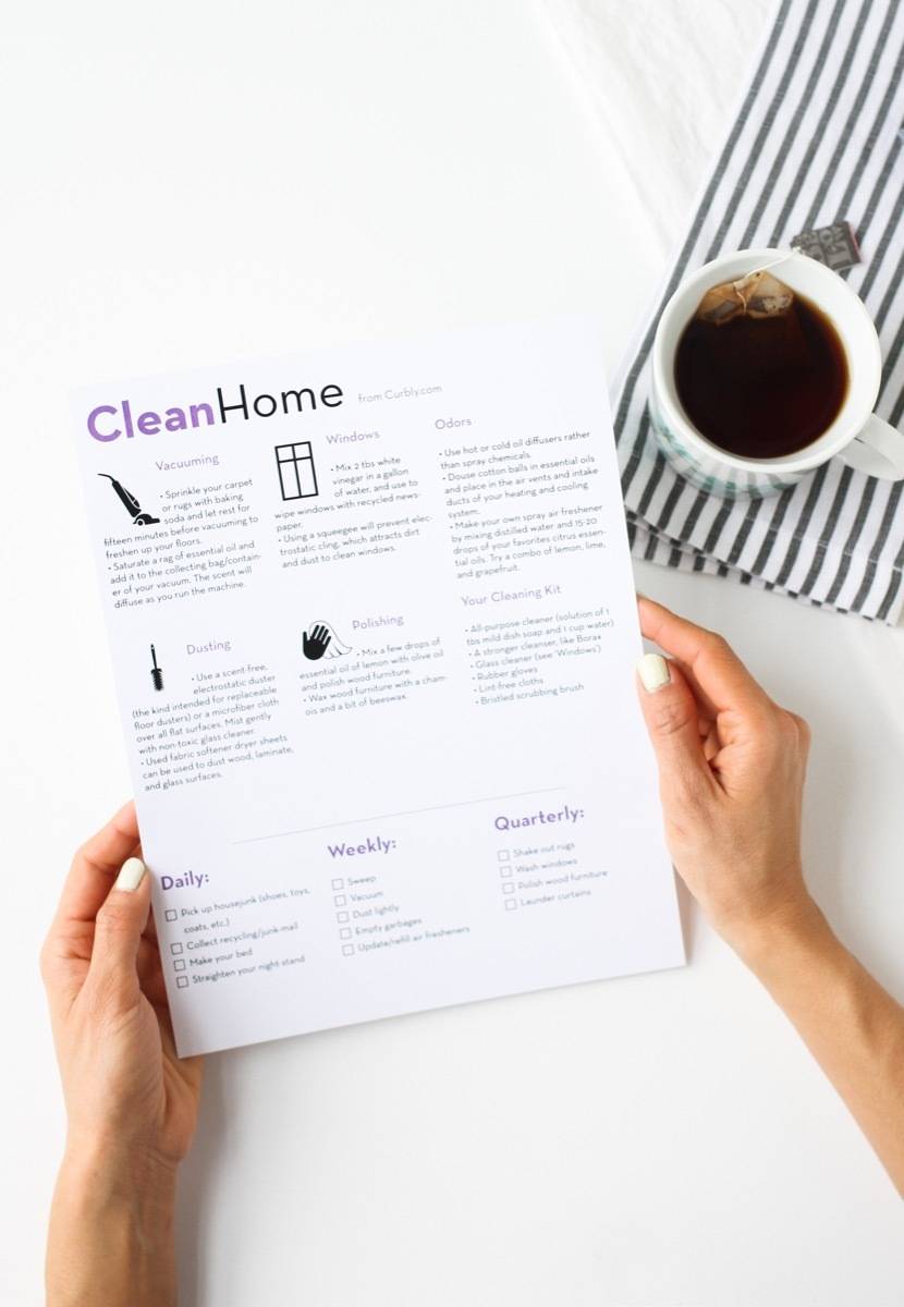 A person holding instructions for a clean home next to a cup of coffee.
