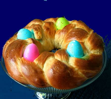 Round shaped baking bread with colorful decorative eggs on it.