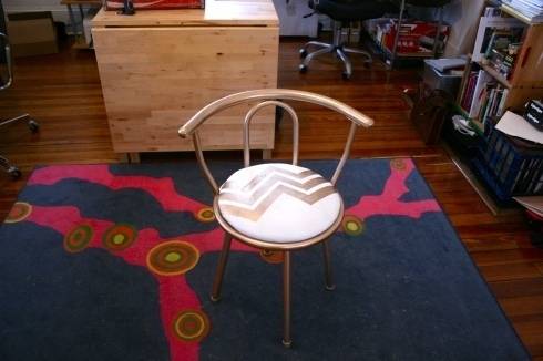 "Chair is on the blue carpet."