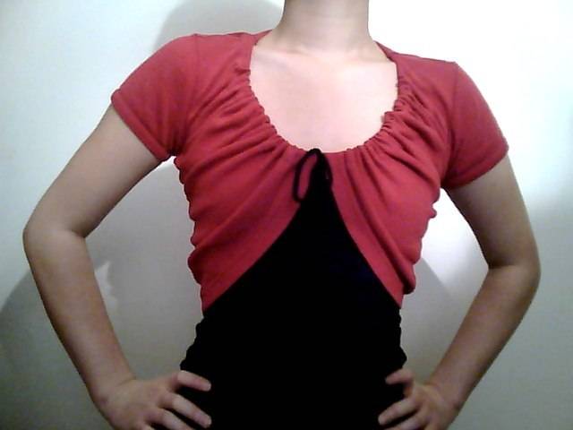 Woman with red and black color t-shirt is holding her hands in her hips.