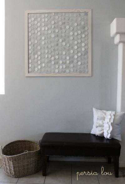 A wall hanging made of shells in a room.