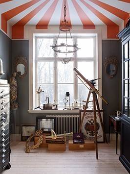 A room containing a telescope with a striped pattern roof painting.