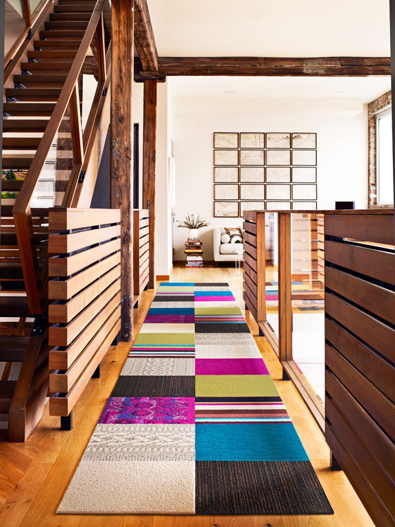 A multi-colored runner near a wooden staircase.