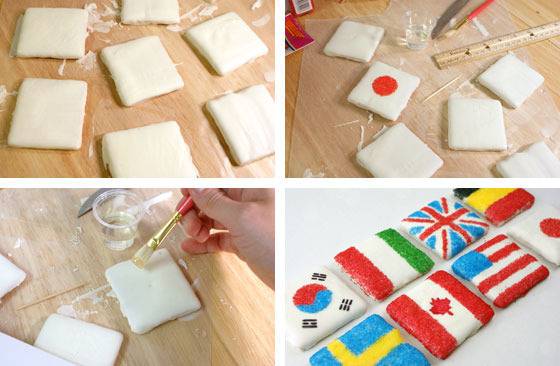 Person making country flags by painting on square pieces.