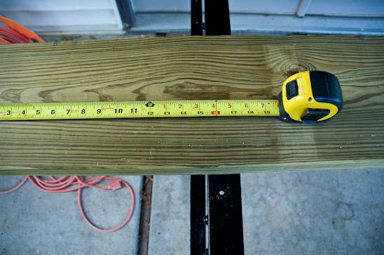 A board of wood with stretched out measuring tape on it.