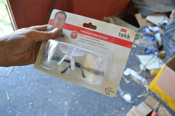 A person is holding a pair of 3M goggles in the package.