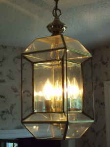 A lit pendant light with many glass panes.