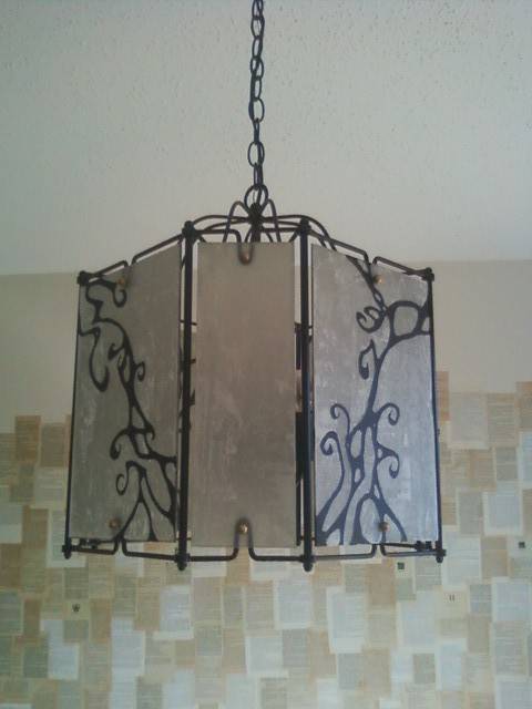 A chandelier made of glass, framed with metal, hanging by a chain.