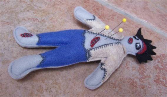 A voodoo doll with three pins in it.