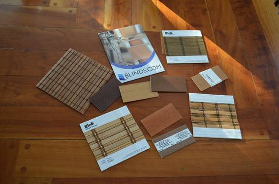 Window covering swatches are laid out on wood.