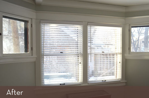 A couple of windows with white blinds.