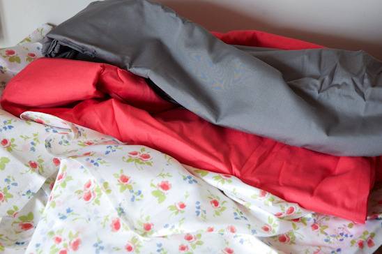 Half folded red, gray and floral white fabrics.