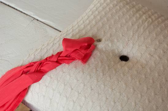 A braided pink material near a white pillow.