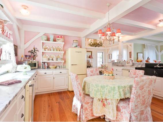 A kitchen and dining room with many pink flower decorations.