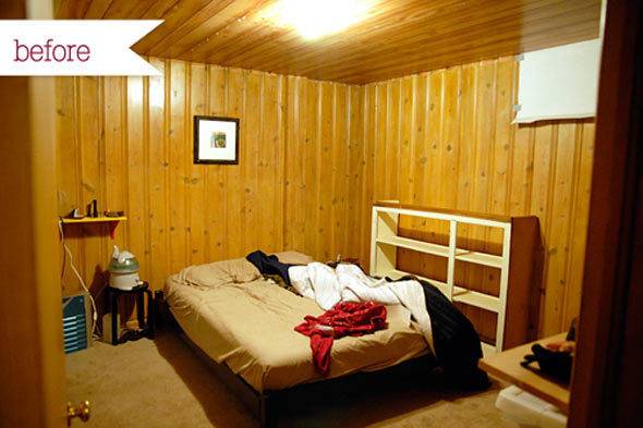 An unmade bed sitting in a room with yellow wood paneled walls.