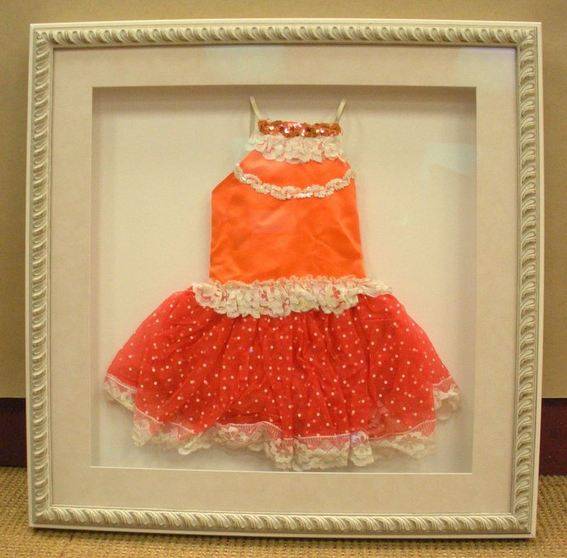An orange and red girls dress inside of a picture frame.