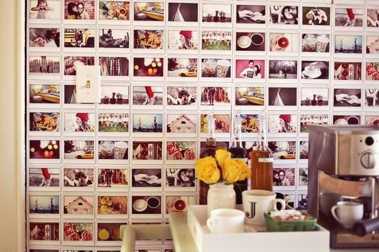 Photos are arranged in a grid on a wall behind a lightswitch.