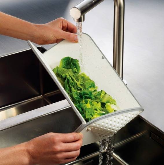 Woman washing leafy vegetables with washer.