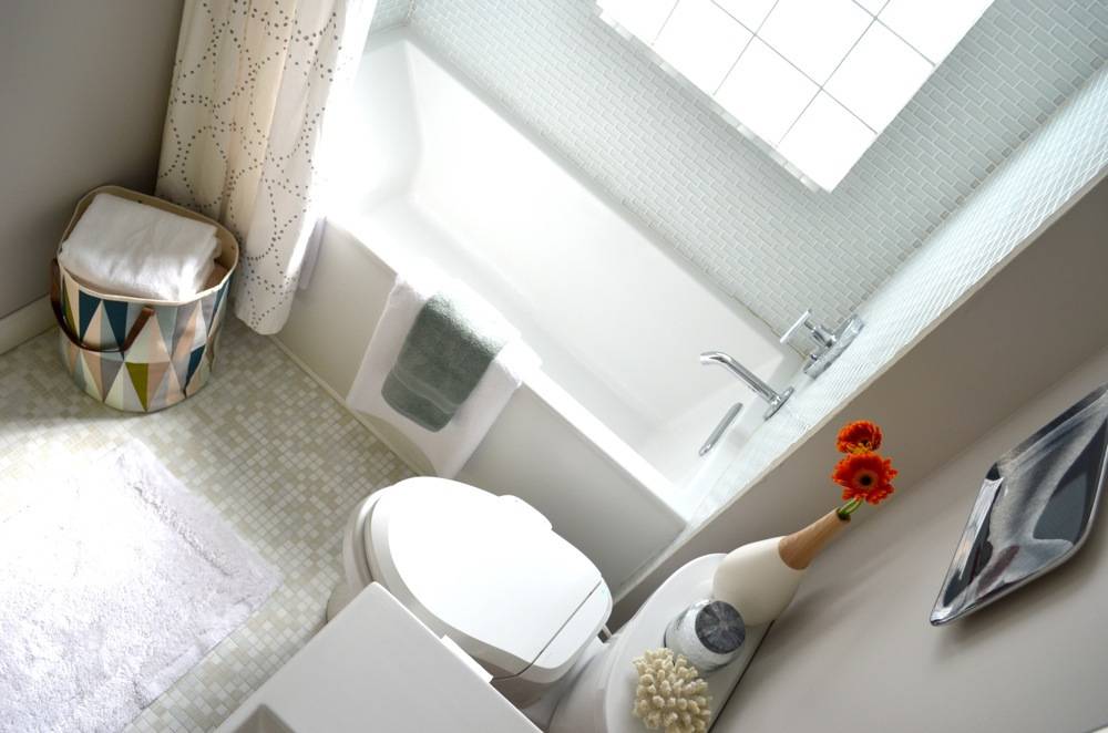 Bathroom makeover with laundry basket flower vase, toilet commode and  bathtub.