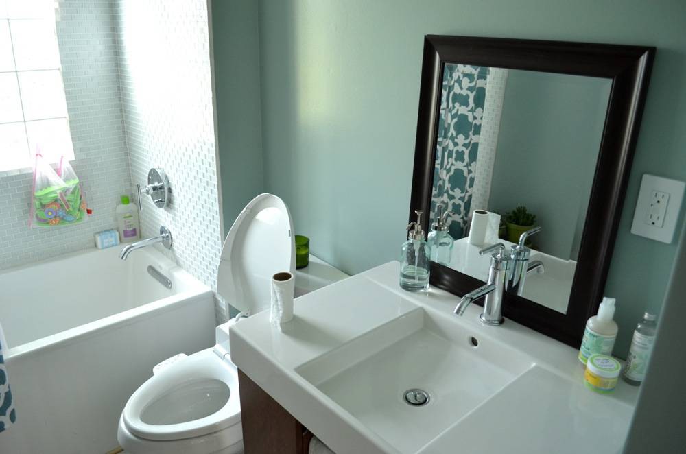Bathroom with toilet commode, washbasin with mirror.