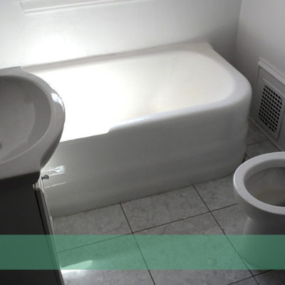 A toilet, tub, and sink sit in a small bathroom.