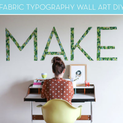 Woman working in workspace in front of typography art wall.