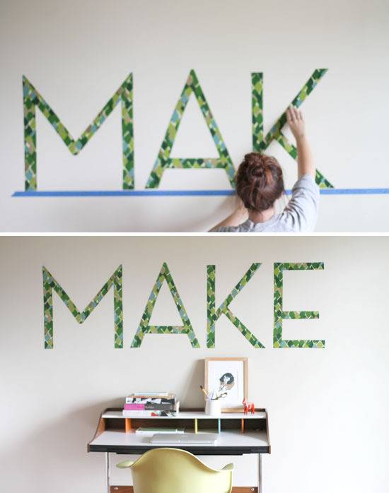 Woman preparing typography art on wall.